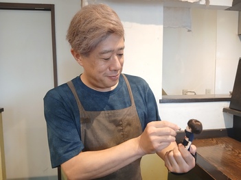 ちびナカノさんと手を取り合う越川オーナー