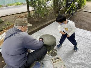 ベーゴマを教わる子どもの様子