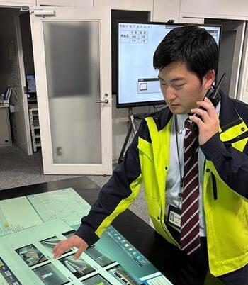 事務職の職員がトランシーバーで連絡をとっている写真