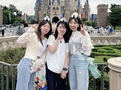 事務職の職員が休日に同期と共にテーマパークにいる写真